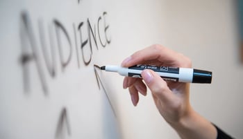 La mano di una persona che scrive su una lavagna