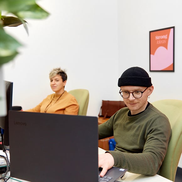 Digital strategist e HubSpot specialist in ufficio mentre lavorano ciascuno con il proprio computer. 