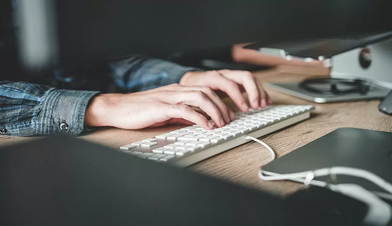 Mani di una persona sulla tastiera di un pc