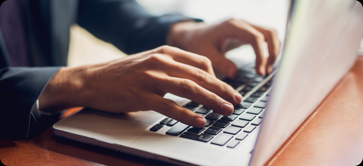 Mani che digitano sulla tastiera di un computer portatile