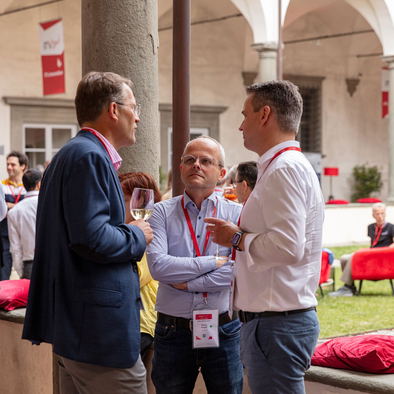 Tre uomini mentre parlano durante l'evento.