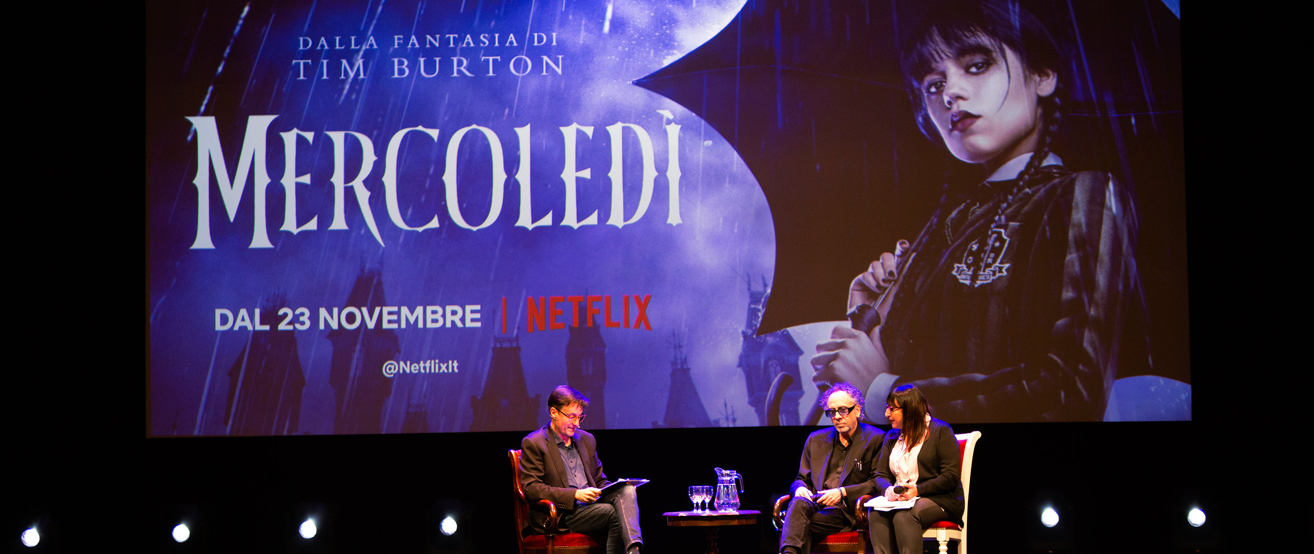 Intervista di alcuni ospiti al festival Lucca Comics di fronte a una schermata della serie Netflix 